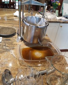 Winepress with tincture flowing into a glass container